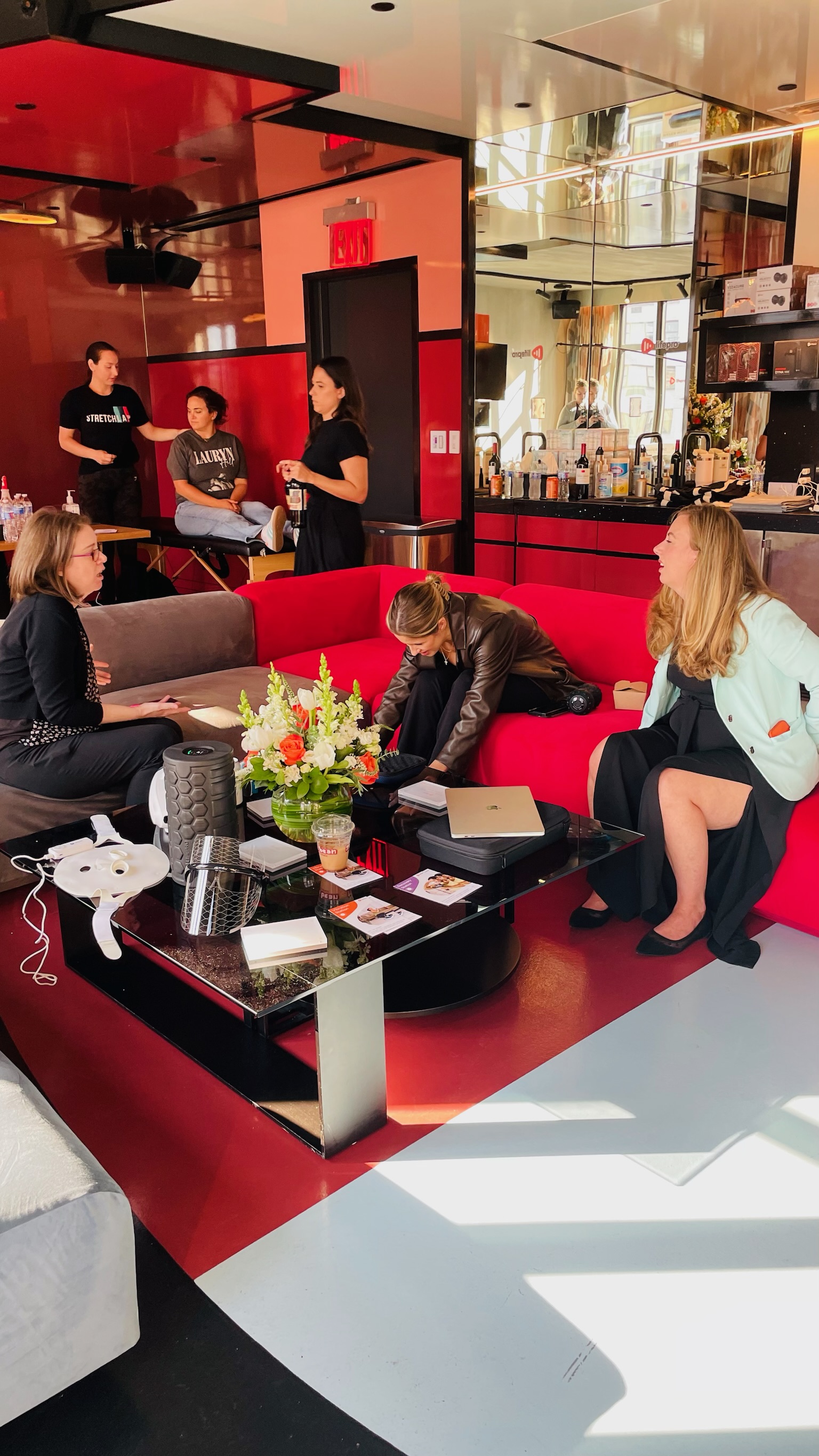 A group talking and trying products around a table at the Lifepro lounge event